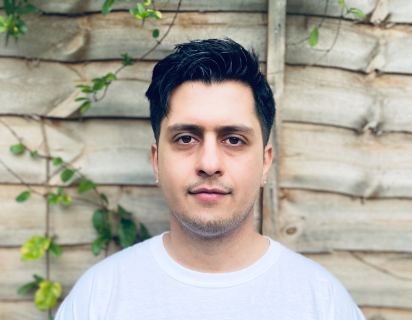  Bilawal Atta, is south Asian with Short black hair, 5'9, medium build, wears ear studs and is wearing a white t-shirt with the words "youth" written on it in purple and in Japanese.