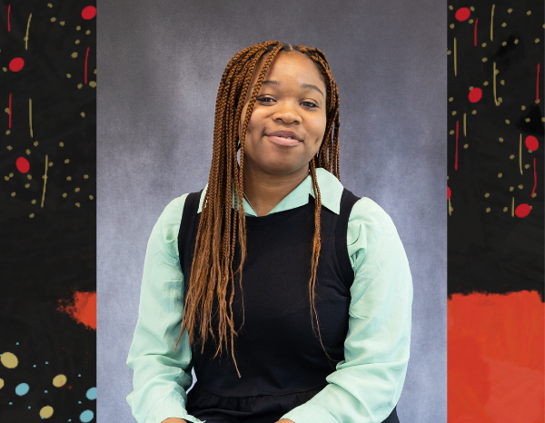 Black woman wearing green shirt and black dress. She is sat upright with a smile on her face and head tilted to the right. Black woman wearing green shirt and black dress. She is sat upright with a smile on her face and head tilted to the right.